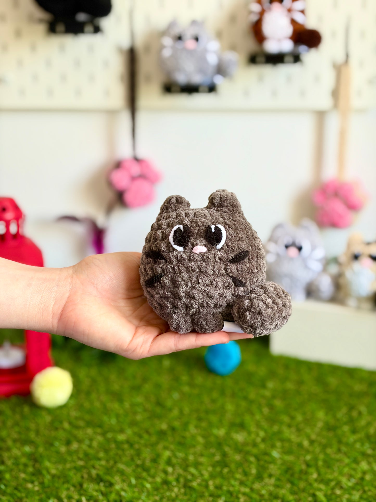 Chat Flouf grand modèle de la marque Nuiba, assis avec un pelage doux et des yeux expressifs, visible sur l'image.