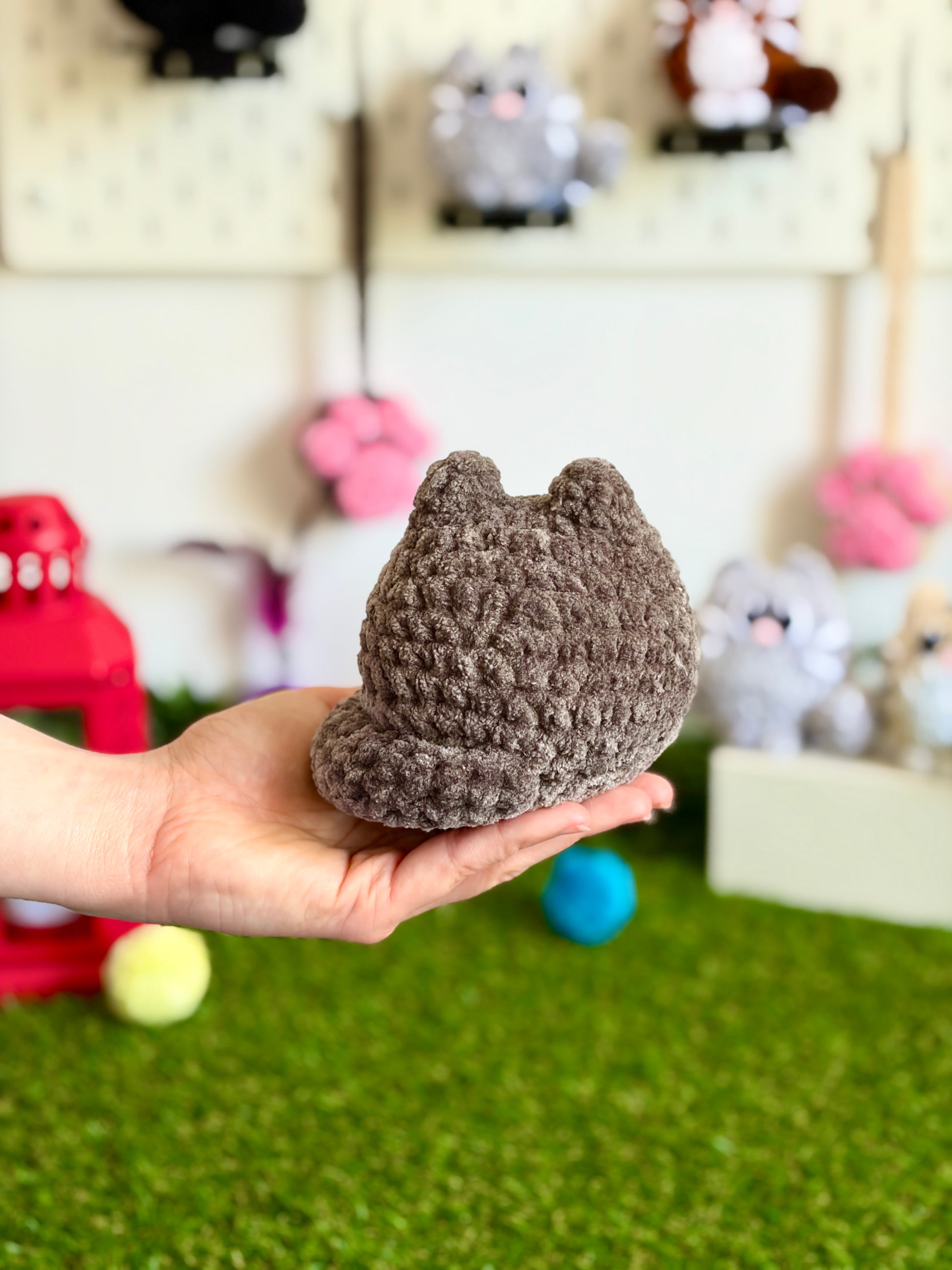 Chat flouf Nuiba, grand modèle, assis et souriant, en peluche douce avec des couleurs pastel, pour décoration ou câlins.