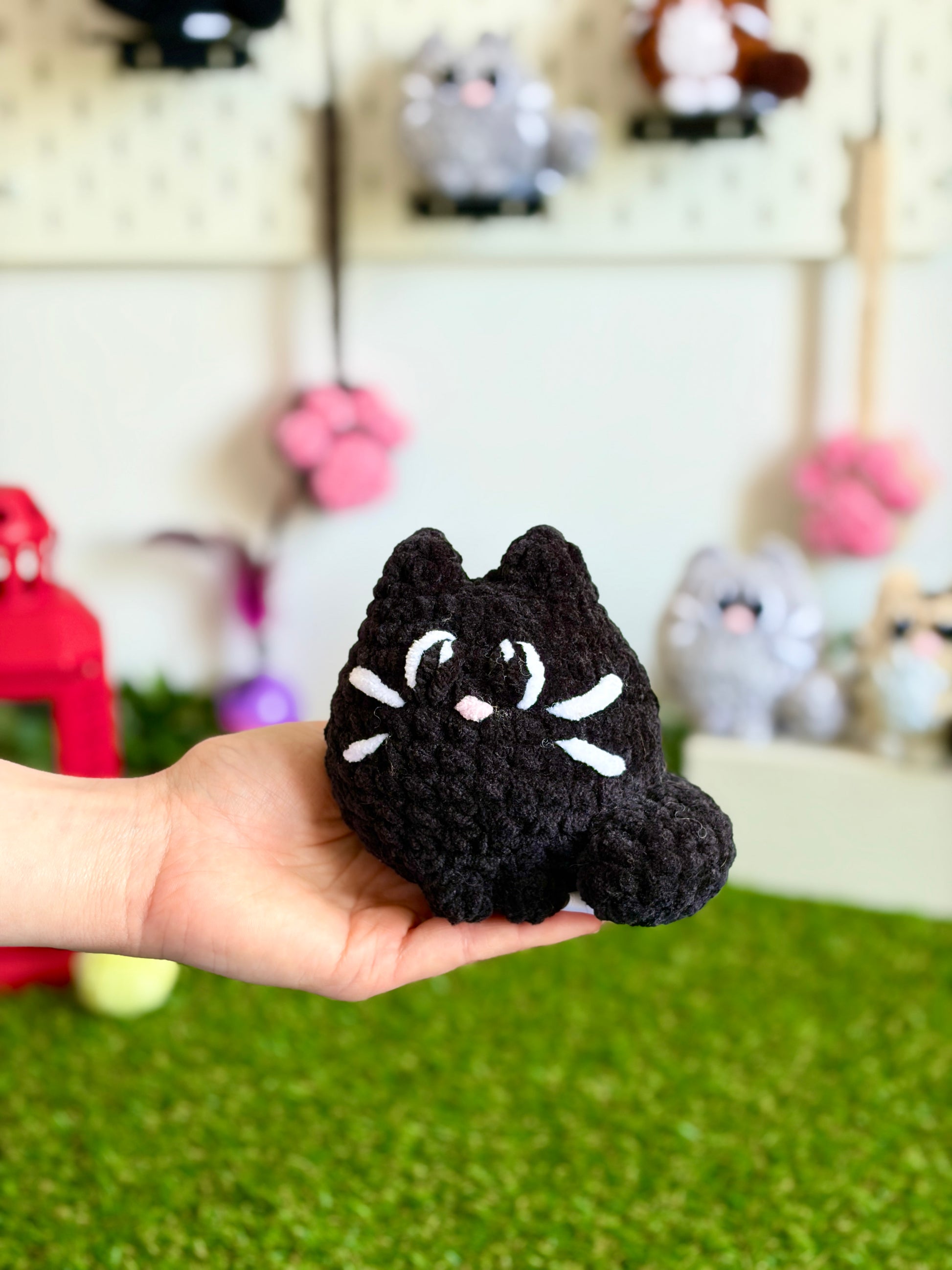 Chat flouf Nuiba, grand modèle, en peluche douce avec yeux brillants et oreilles pointues, assis et prêt à jouer.
