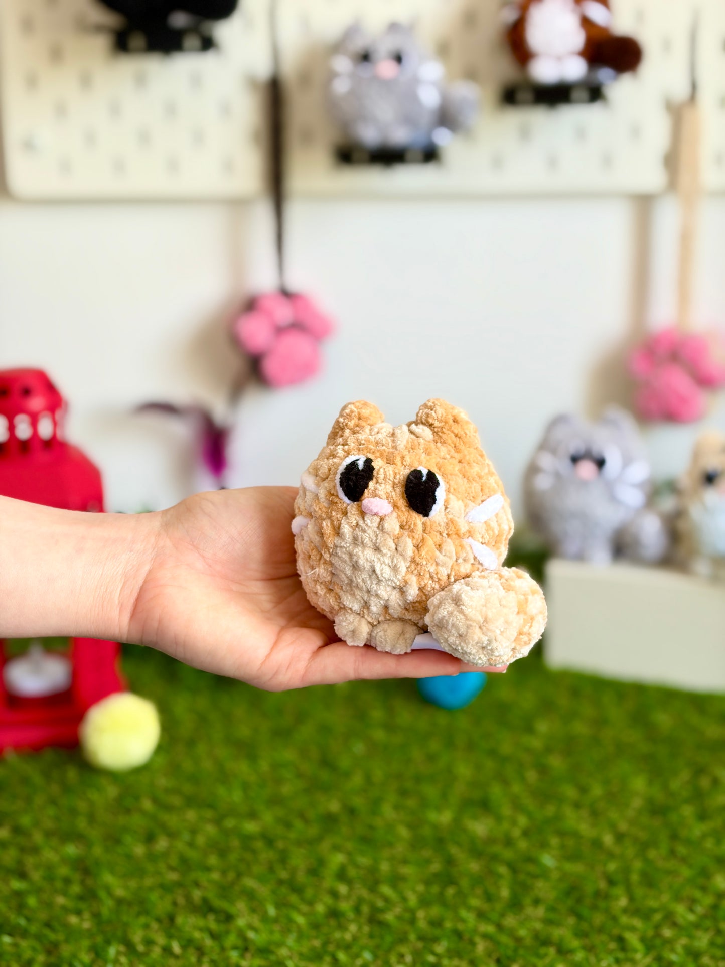 Chat Flouf Nuiba, grand modèle, en peluche douce avec yeux brillants et queues moelleuses, assis sur un fond neutre.