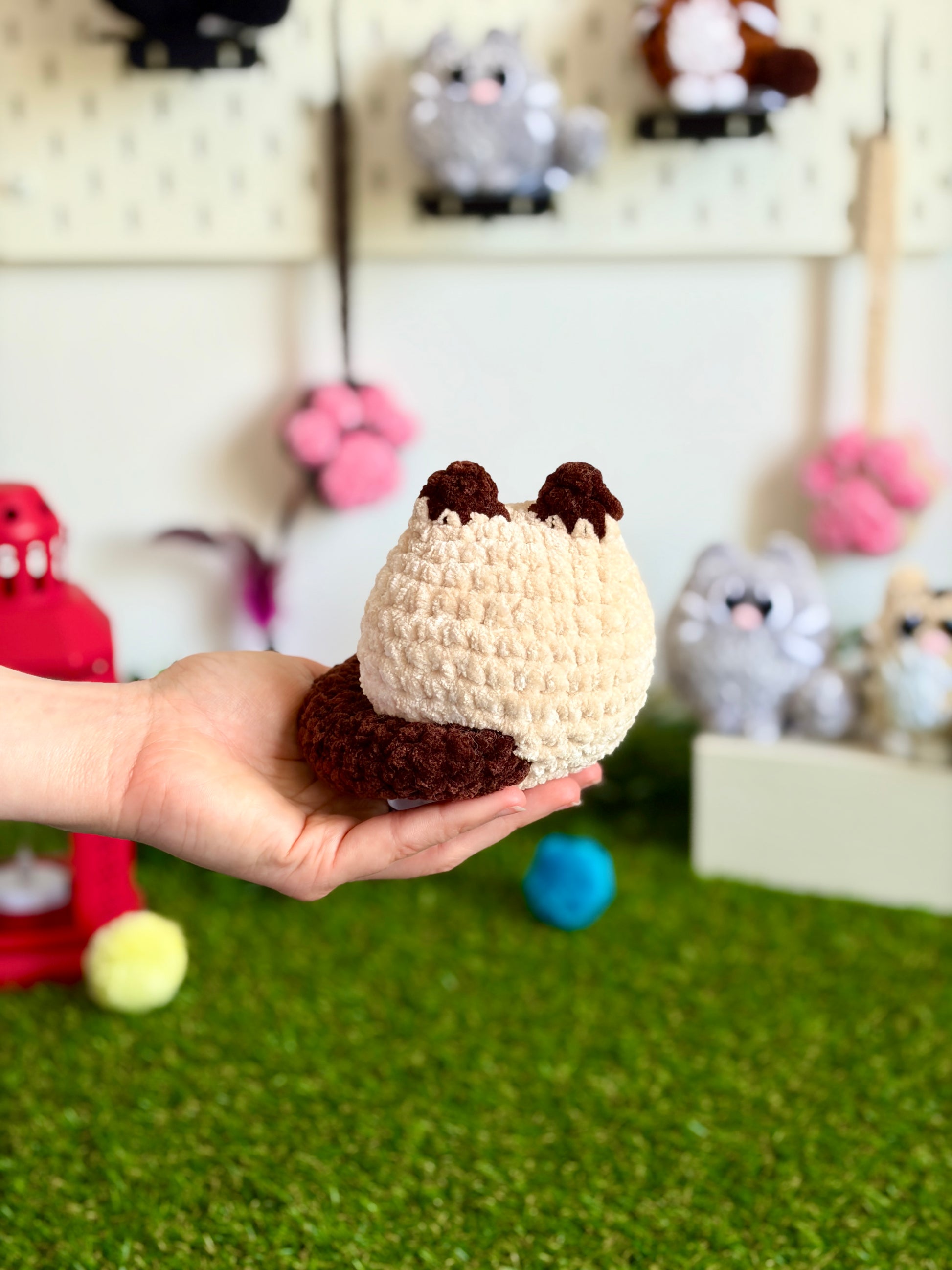 Chat Flouf grand modèle de la marque Nuiba, peluche douce et colorée, assis avec regard attentif, pour collection ou décoration.