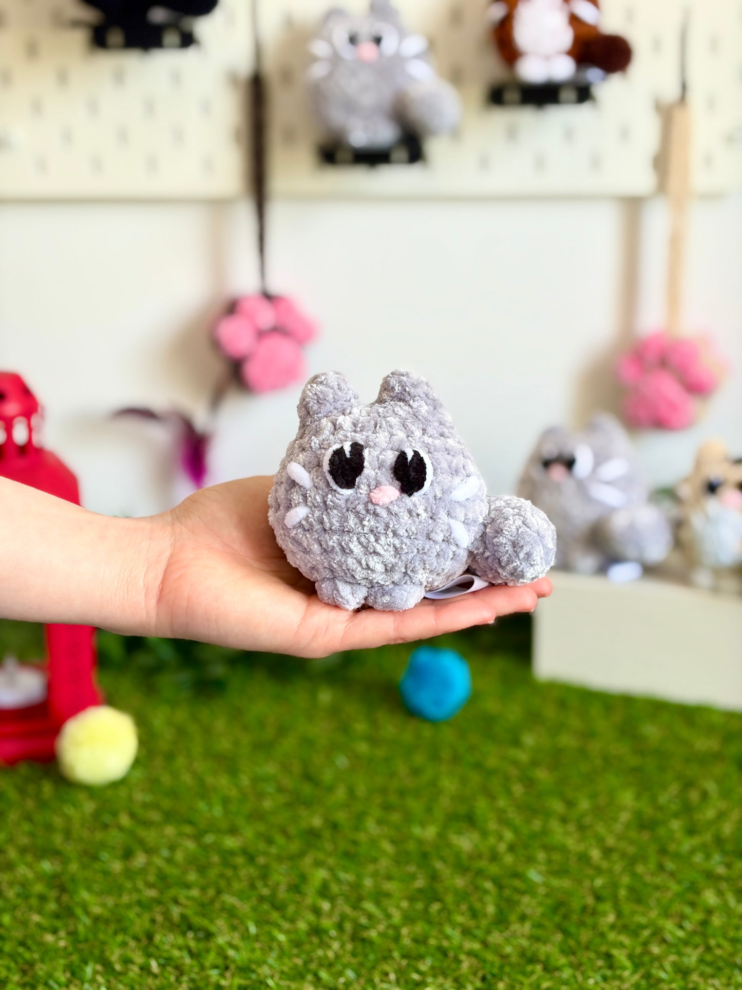 Chaton flouf Nuiba, petit modèle avec pelage doux et blanc, posé sur une surface neutre, visible en détail.