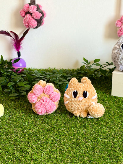 Gros plan du pack chat Flouf Nuiba avec pendentif patoune en forme de chat en peluche et accessoire pour animaux domestiques.