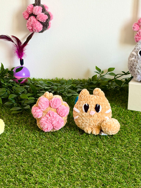 Gros plan du pack chat Flouf Nuiba avec pendentif patoune en forme de chat en peluche et accessoire pour animaux domestiques.